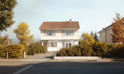 a large white house is next to some trees