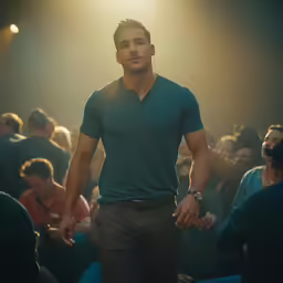 man standing in front of crowd of people, with arms spread wide and head tilted