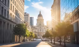 the sun shining on the street in front of the building