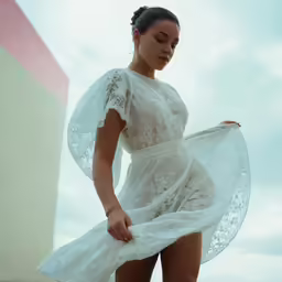 a beautiful woman in white dress posing