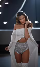 a young girl with white clothes is walking down a runway