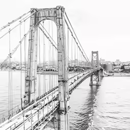 black and white photograph of the manhattan bridge from across the river