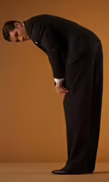 a man standing in front of a wall with his hands over his hip