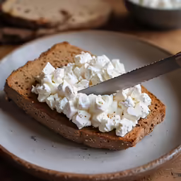 someone slicing up some bread with a knife