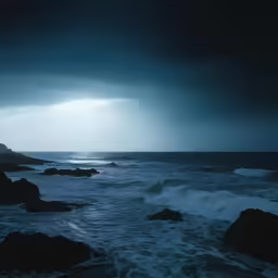 an ocean view in the night with dark clouds