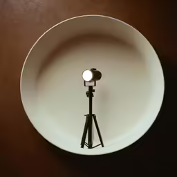 a spotlight in a white bowl with a tripod