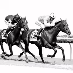 two men racing horses around the track in motion