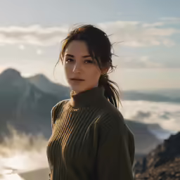 a woman stands near mountains during the day