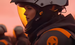 a woman wearing a helmet and looking off into the distance