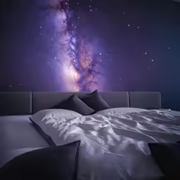 a bed with pillows, blanket and wall mural in purple