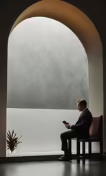 a man sitting in a chair holding a smart phone