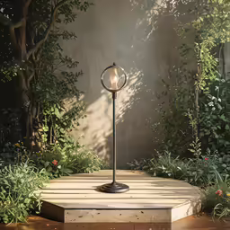 a glass light fixture in the middle of some grass
