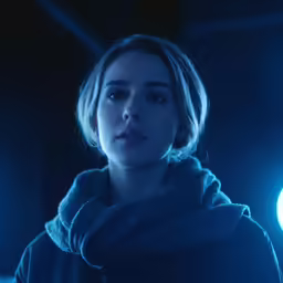 the woman is dressed in black and blue lights