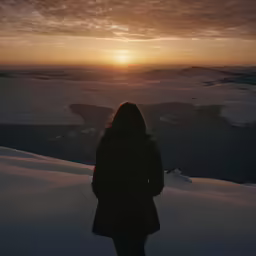 a person looking down at the sun in the distance