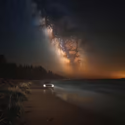 car going by stars in the sky on the beach