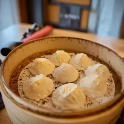a bowl filled with dessert next to a table