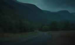 an empty road near the mountains at night
