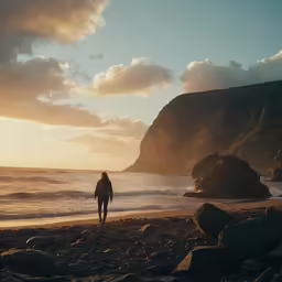 a person walks on a beach with rocks around