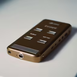 an iphone that has three buttons, placed on a table