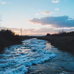 the sun is setting over an icy river