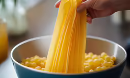 someone is holding a yellow napkin above the corn