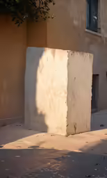 a square object made out of concrete and cement mortar, sits on the sidewalk