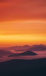a mountain with many hills under a sunset