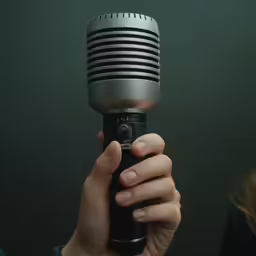 the girl is holding an old microphone