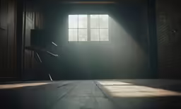 an empty chair facing a window with light streaming through