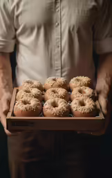 man holding up a box of doughnuts