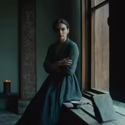 woman wearing green sitting on ledge with candles in background