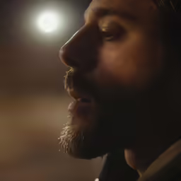 closeup of a man in profile with head light behind him
