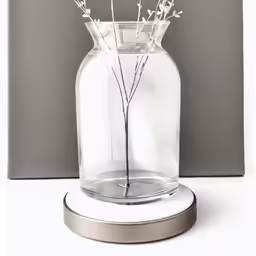 a glass vase with a metal stand and flowers