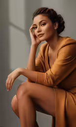 a woman with a gold sweater on sitting down