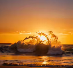 the sun setting with waves crashing into shore,the sun setting behind a wave crashing at the beach