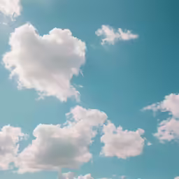 a cloud filled sky has a plane flying in the middle