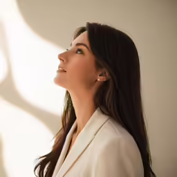 a woman in white is looking up at the light