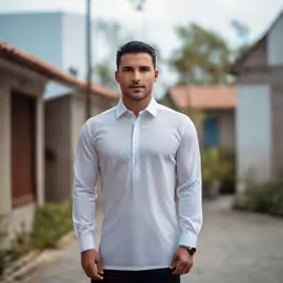a man standing on a street in a white shirt