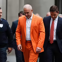 two men in suits walking on the street