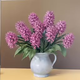 there is a gray vase holding some pink flowers