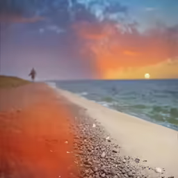 someone is standing on a rocky beach watching the sun go down