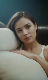a woman is posing with her pillow over her shoulder
