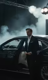man standing next to his black bmw car