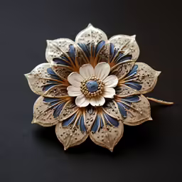 a flower brooch sitting on top of a black surface