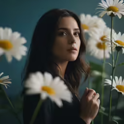 a young woman standing in front of a field of daisies
