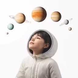a young child with a hoodie on has drawn planets above her head