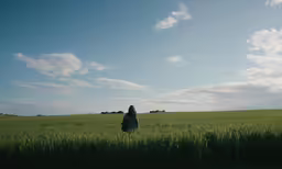 a woman walks through the tall grass in the field