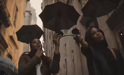 four women holding umbrellas next to each other