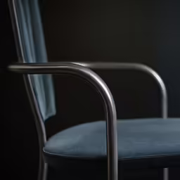 the black chair with a blue back cover sits in front of a black wall