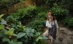 girl walking in the garden looking through her cell phone